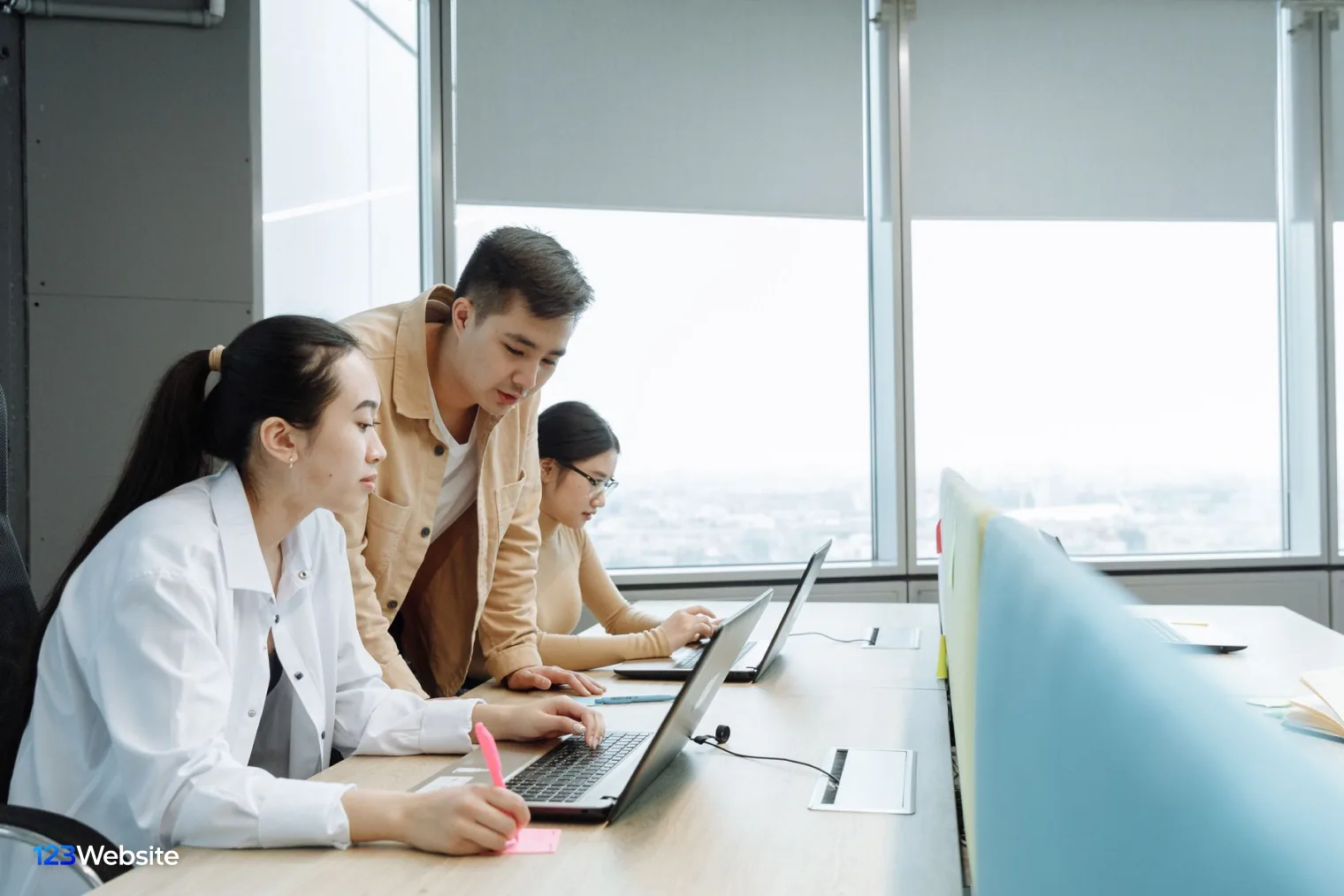 Project team discussing around a laptop while connecting Shopify to the warehouse system