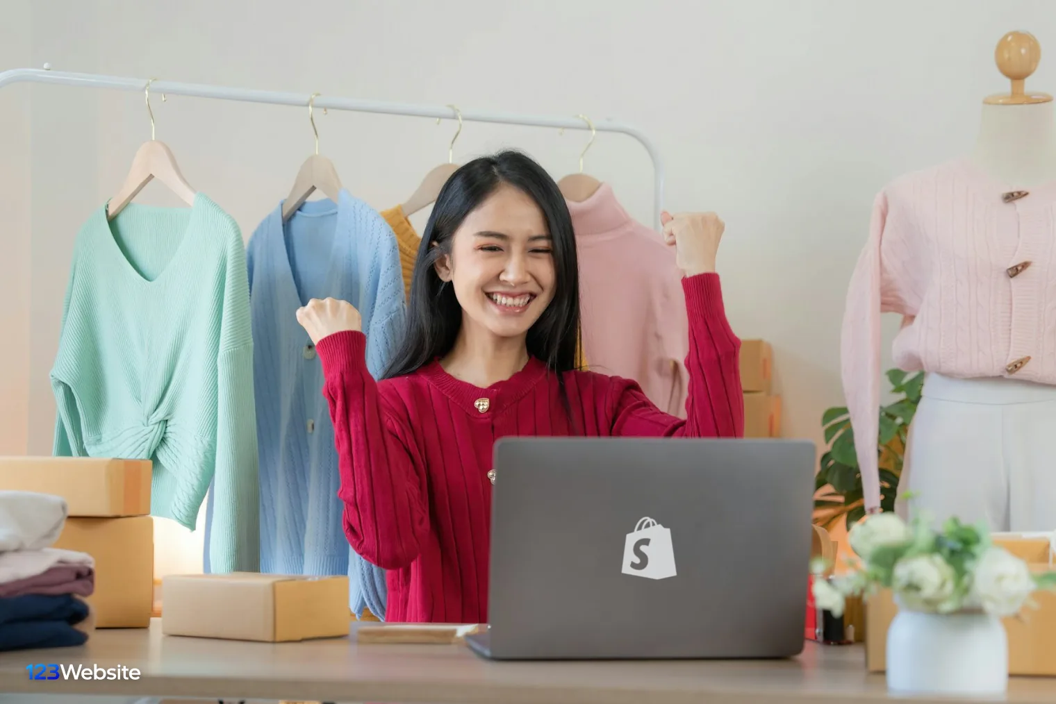 Shop owner managing orders on a laptop next to parcels for a Shopify store